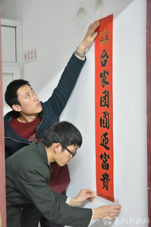 寒假留校学生（写）贴春联，弘扬中华传统文化。