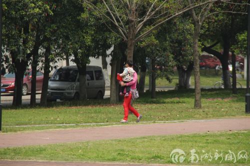 奶奶带着小孙子在广场上散步