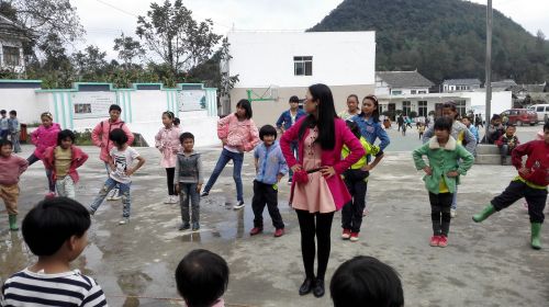 志愿者陈丽在教各年级学生代表做广播体操