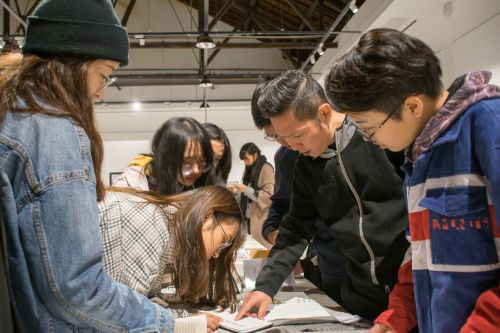 艺术设计系系主任张权老师为同学们讲解作品【学通社记者 周奕淳 摄】