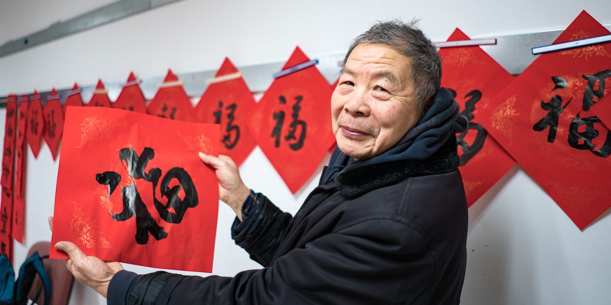 老人开学的向同学们展示所写的福字写福 【学通社记周奕轩 摄】 (7)