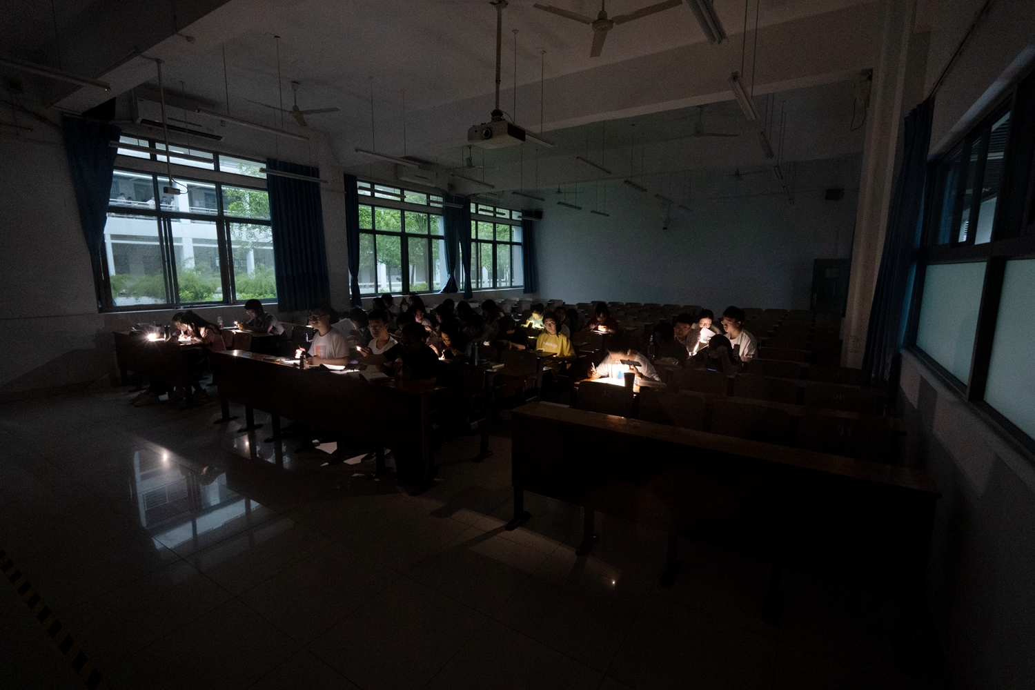 华中农业大学第三教学楼，突发停电，同学们在漆黑的教室中凭借手机灯光学习（学通社记者 刘博文 摄）