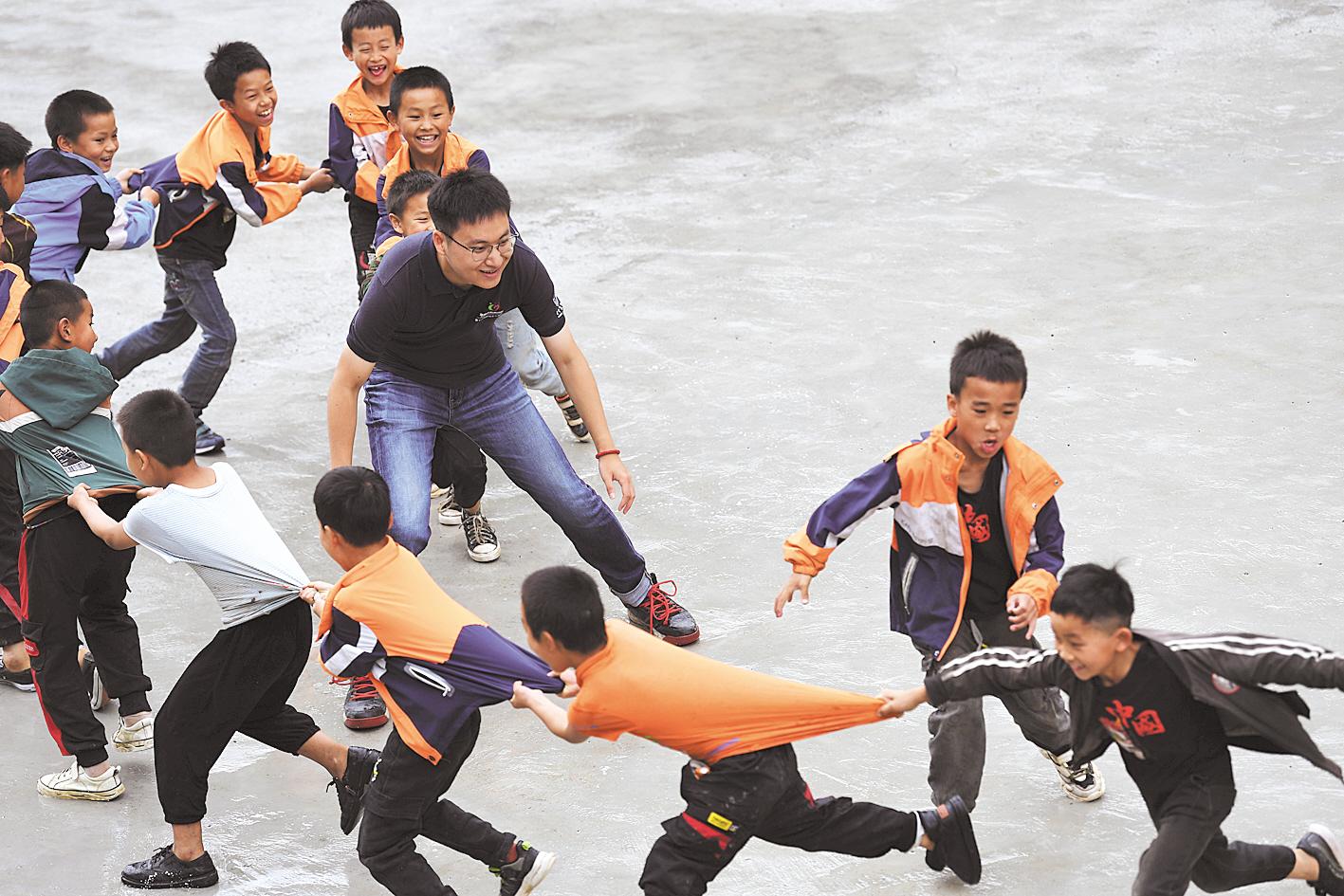 6月30日，贵州大方为民小学，支教志愿者郭子鸣和孩子们玩游戏。