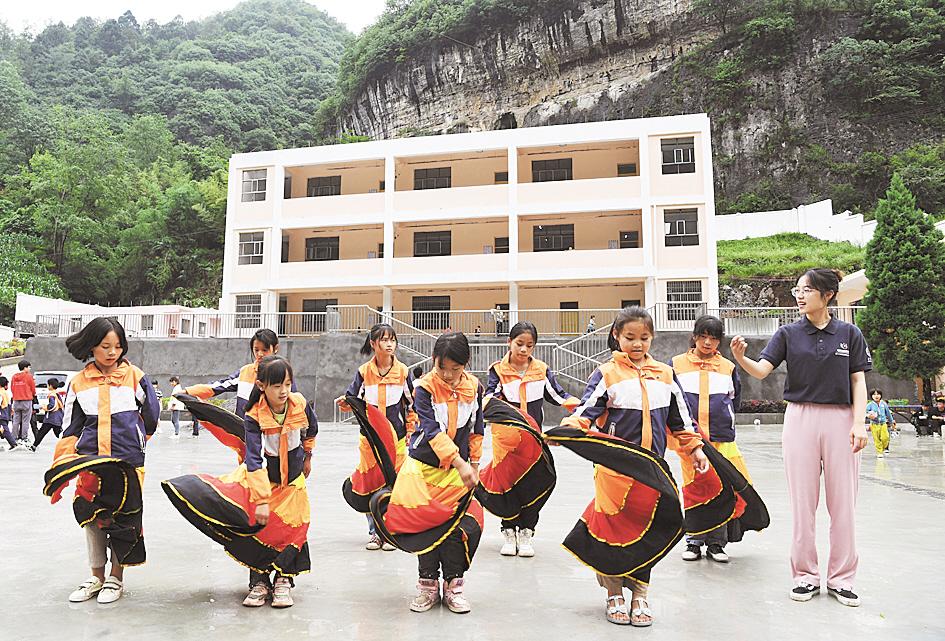 6月30日，贵州大方为民小学，支教志愿者郑晓雪教孩子们练习彝族舞蹈。