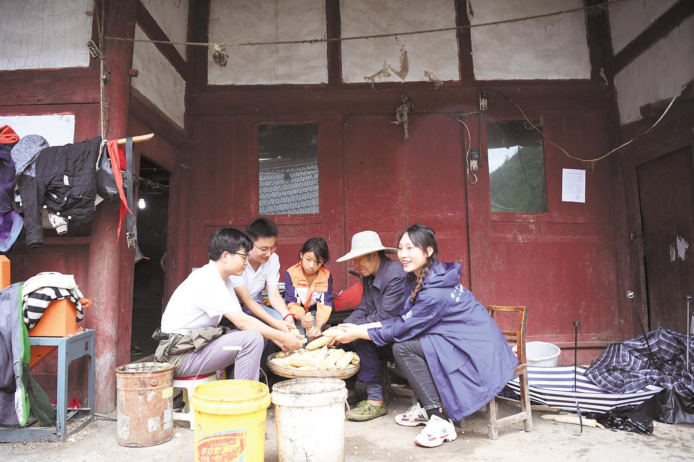 6月29日，贵州大方县猫场镇狗吊岩村，支教志愿者在孩子家帮忙干农活。