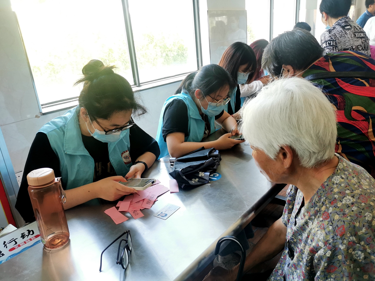 03-社会实践分队同学为接种疫苗的老人建立档案