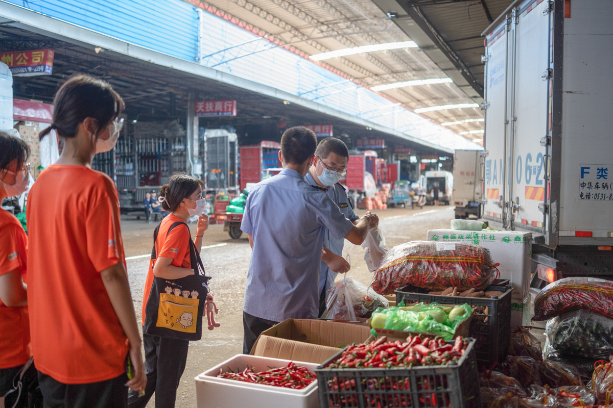 洪山区市场监督管理局成员对白沙洲农副食品大市场售卖蔬菜进行采样（学通社记者 刘博文 摄）