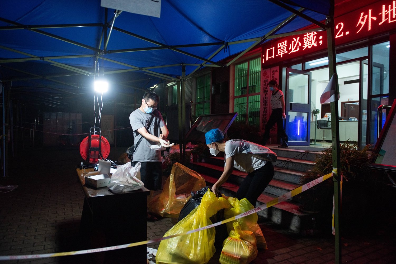 2021年8月10日，华中农业大学东社区检测点，医务人员在检测工作完成后清理医疗废物（学通社记者 段智为 摄）