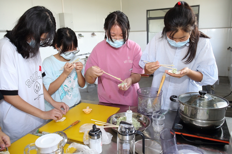 同学们在老师的带领下开始制作饺子