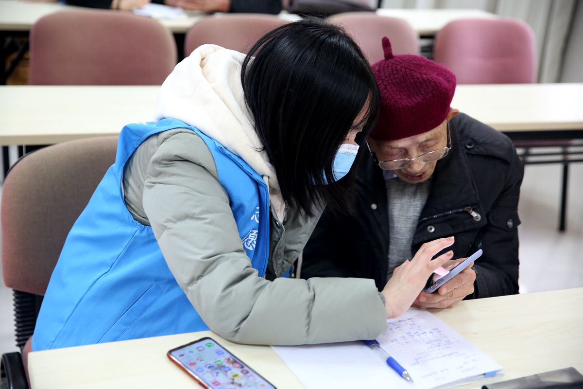 离退休教师在志愿者的帮助下学习使用智能手机（学通社记者 杨怡 摄）