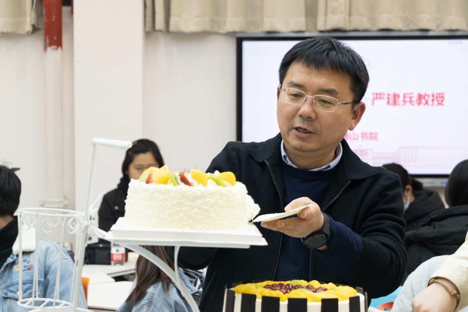 严建兵教授为同学分蛋糕 （曹颖 摄）