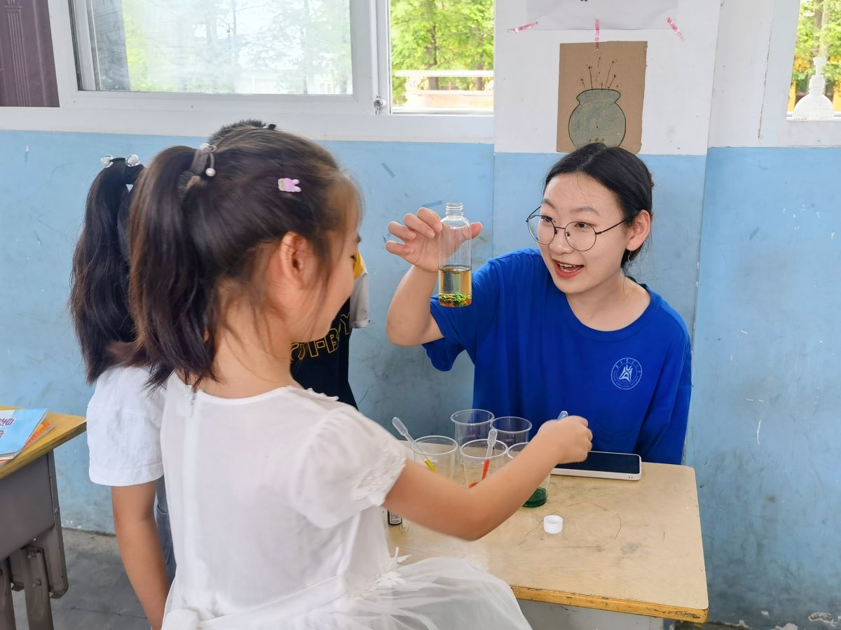 实践团成员给孩子们展示“七彩珍珠雨”趣味小实验 李子依摄_proc