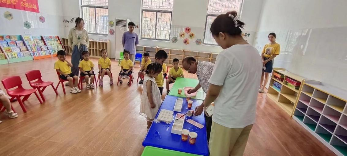 志愿者和李俊在先生一起教孩子们制作粉笔（文法学院 供图）