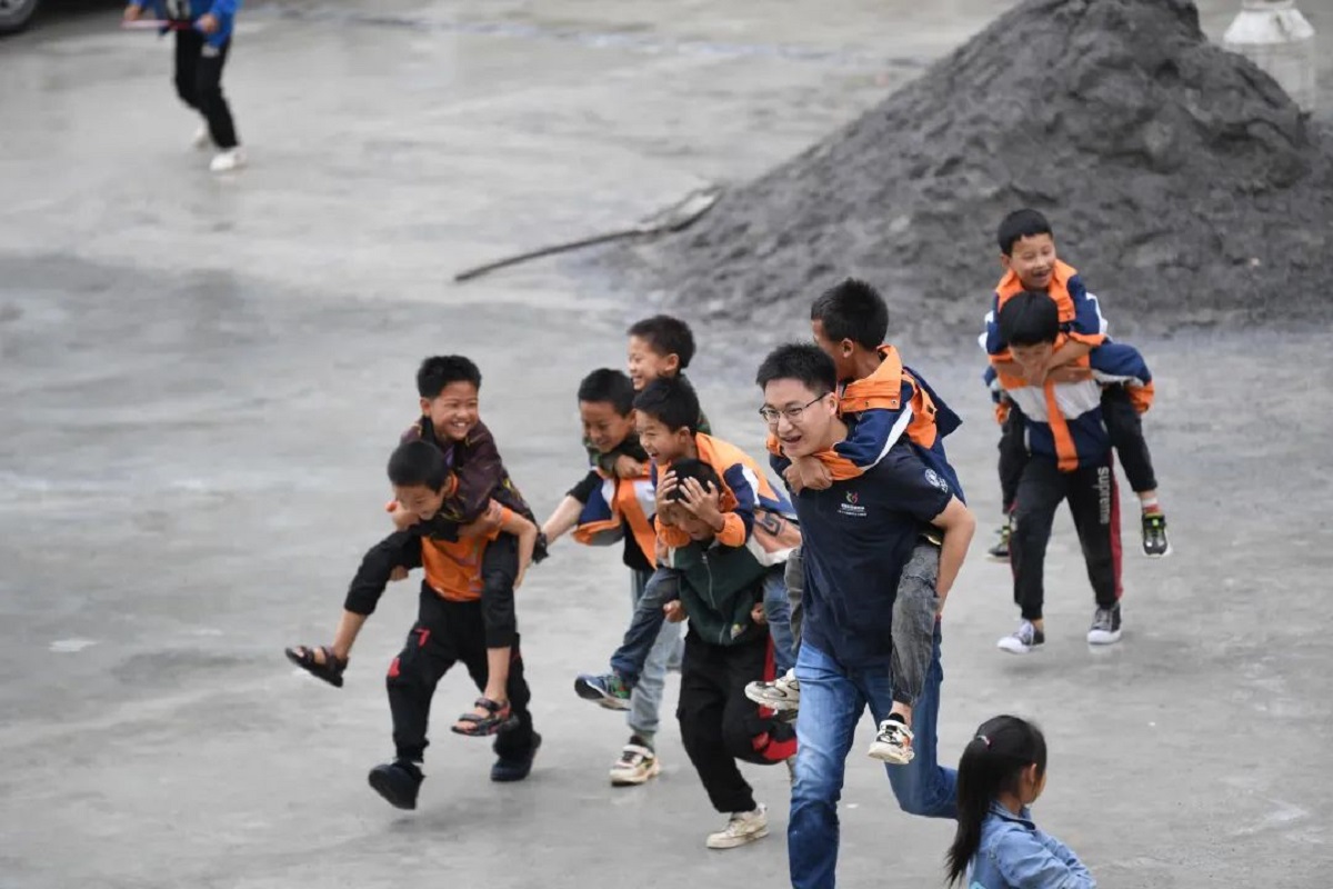 志愿者郭子鸣和为民小学二年级学生玩耍