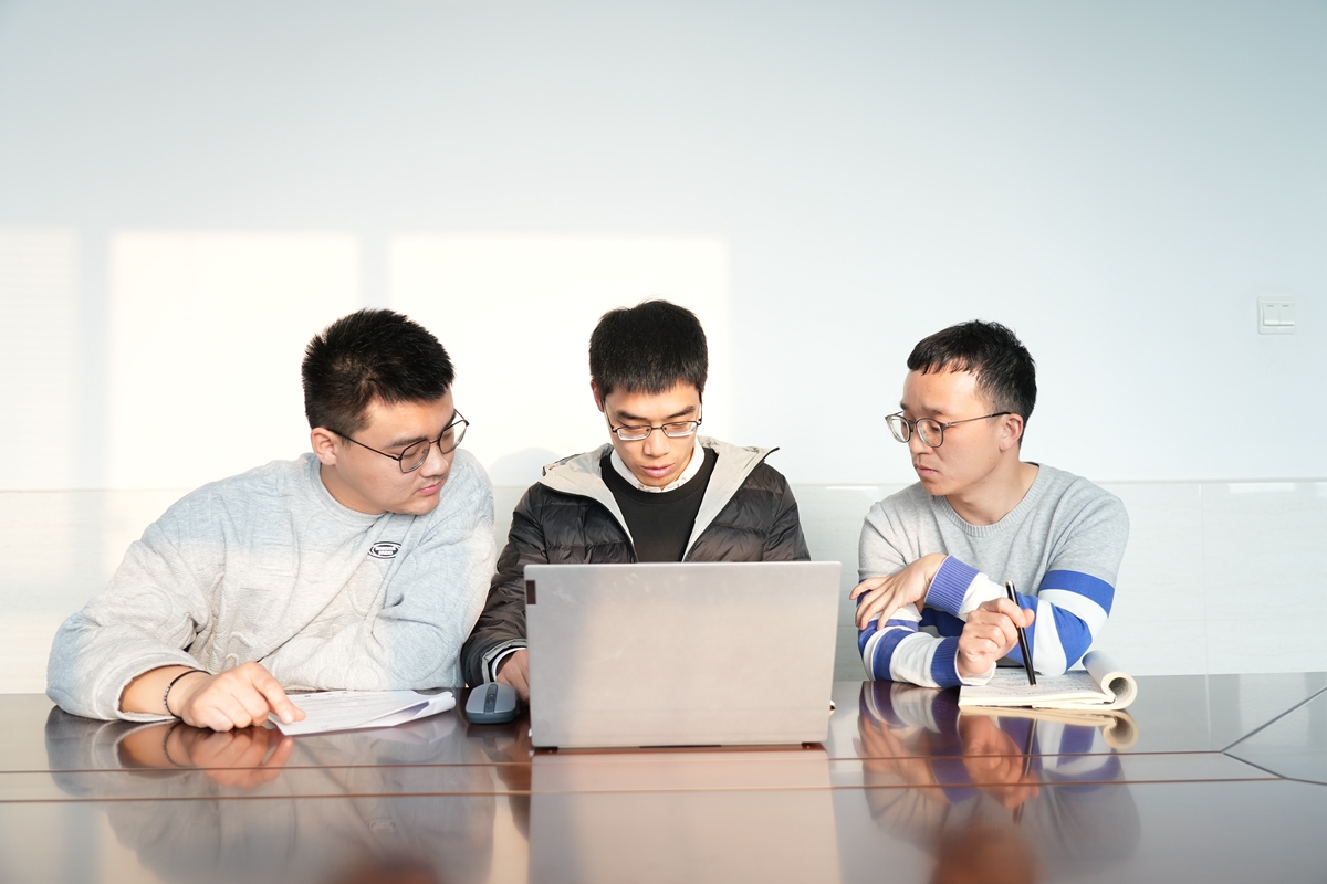博士研究生王正基、周鹏辉与硕士研究生朱兴臣（从右至左）探讨科研问题