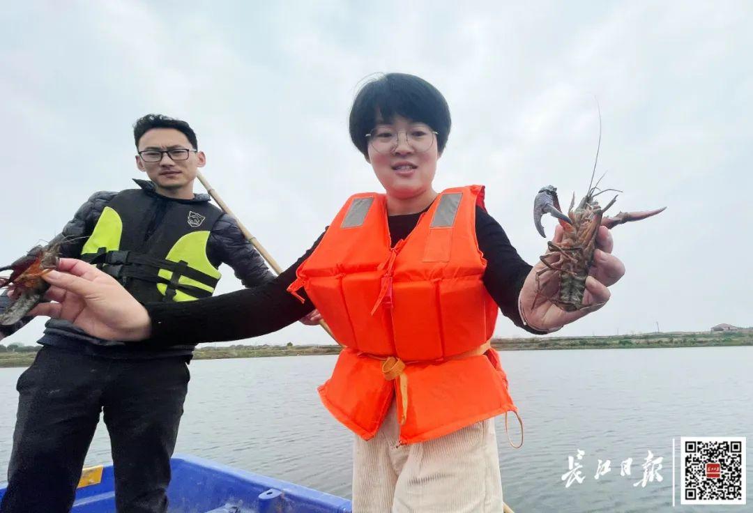 张秀梅（右一）展示手中的小龙虾