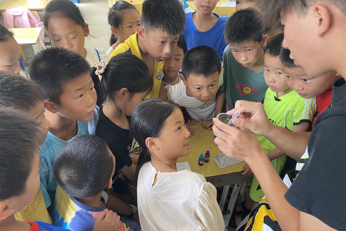 志愿者王泽宇在科学课上带领学生们制作人工种子