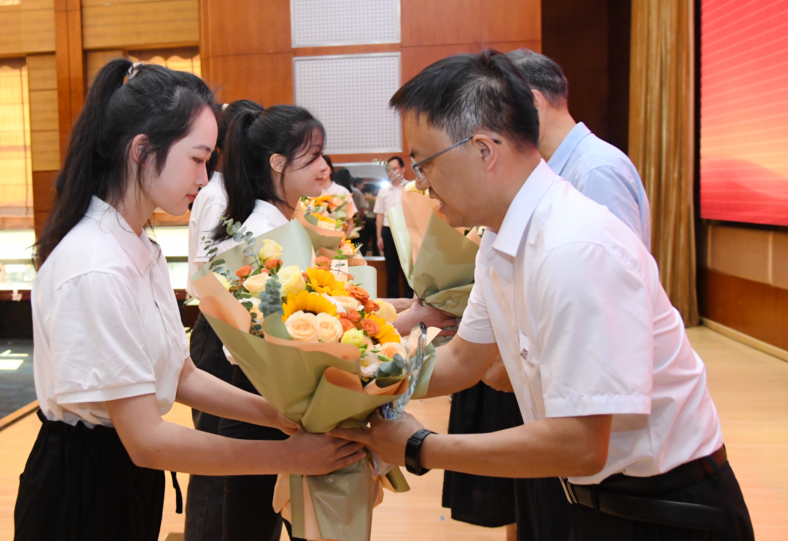 学生代表为从教30年教师代表献花（记者 徐行 摄）