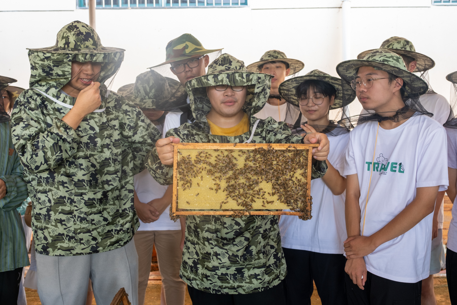 蜜蜂繁育基地工作人员展示蜂箱（学通社记者 周嘉键 摄）