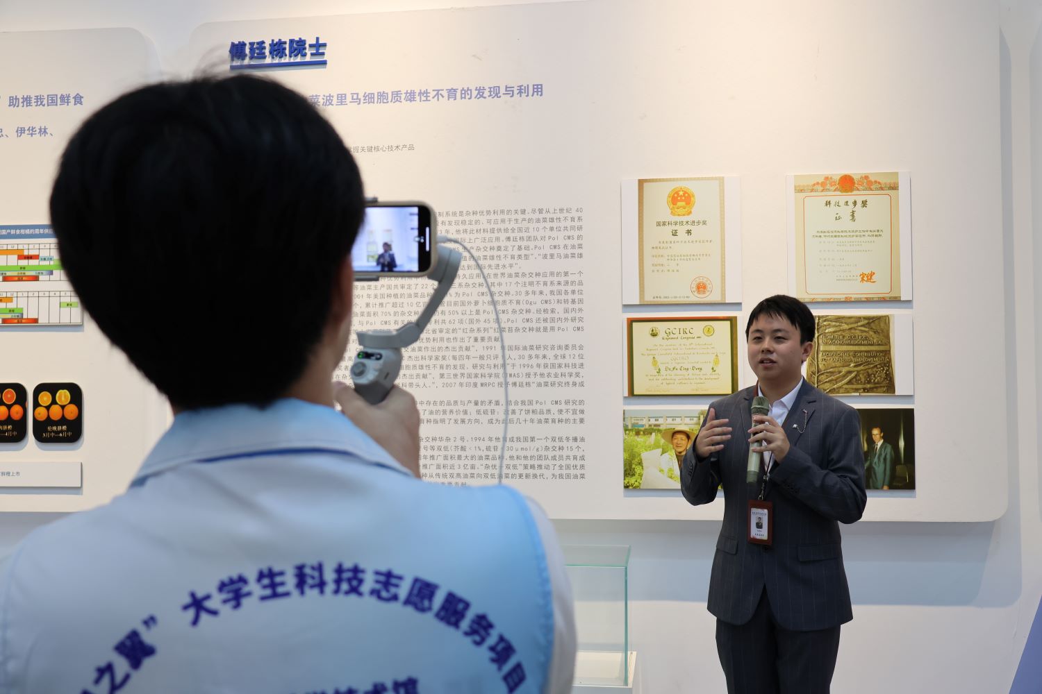 志愿者向孩子们介绍来自华中农业大学的傅廷栋院士的科研成果（李云国 摄）