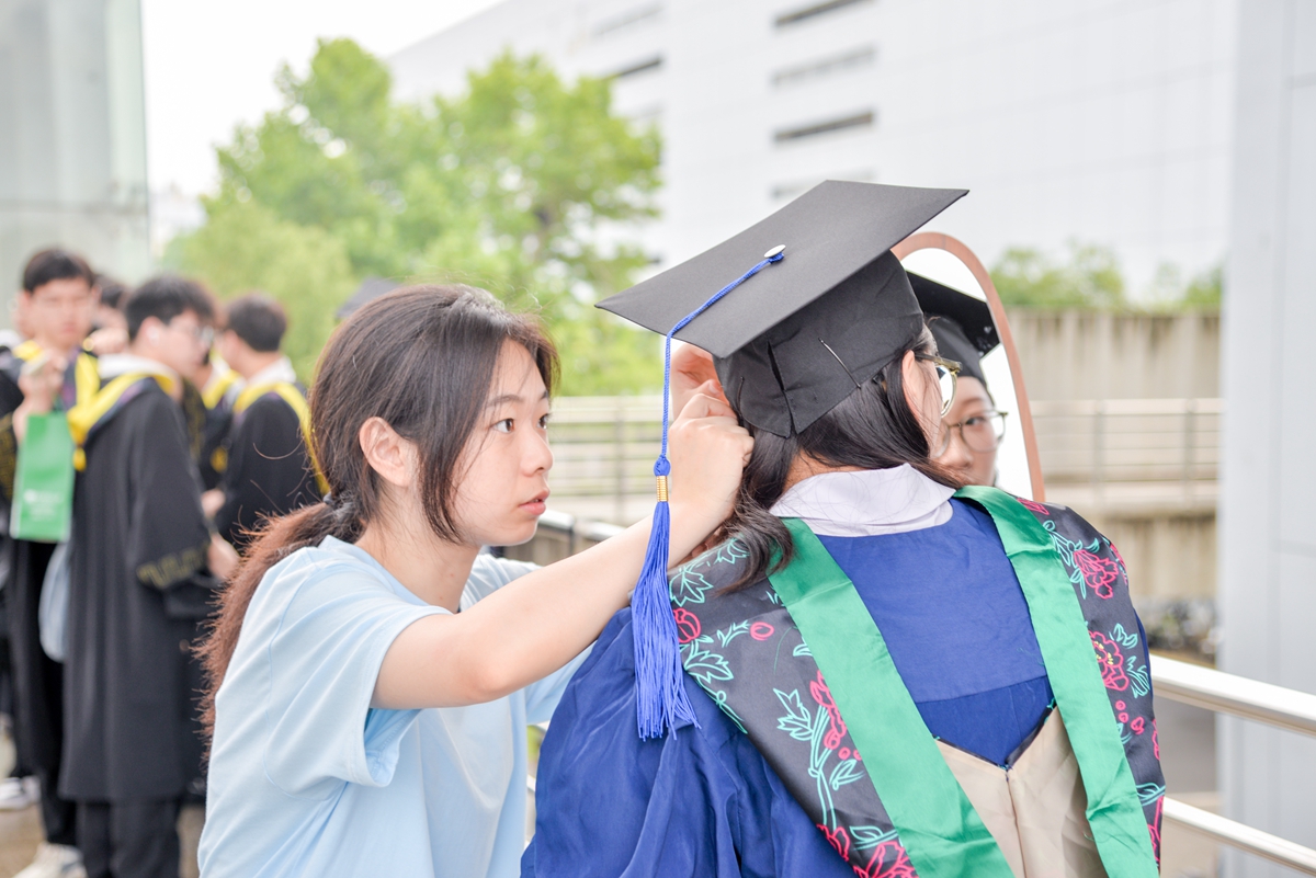 工作人员为同学整理仪容（学通社记者 魏雨城 摄）