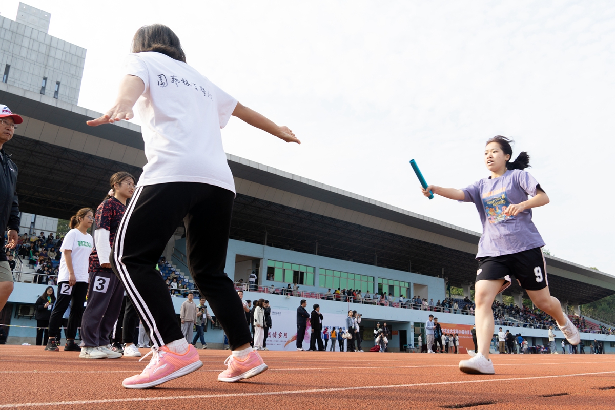 女子4*400接力决赛上交接棒一瞬(学通社记者 吴奕彤 摄)